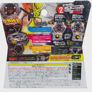 Puede incluir: Una tarjeta de embalaje de juguete Beyblade Metal Fight con una peonza negra y plateada, un lanzador y texto en japon&eacute;s que detalla el sistema 4D, los modos de ataque y defensa, y componentes como la rueda de metal y la base.
