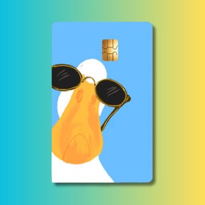 May include: A rectangular credit card skin featuring a light blue background and a graphic illustration of a white duck wearing black oval sunglasses. The design includes a gold-colored EMV chip located at the top center of the card surface.