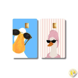 Op de afbeelding: Twee rechthoekige creditcardstickers. De linker sticker toont een witte eend met een oranje snavel en een zwarte zonnebril op een lichtblauwe achtergrond. De rechter sticker toont een witte eend met een roze handdoek en een zwarte zonnebril.