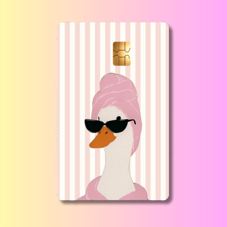 May include: A rectangular payment card featuring a white and light pink vertical striped background. The center displays an illustration of a white goose wearing a pink towel wrapped around its head, a pink robe, and black cat-eye sunglasses.