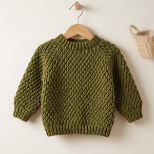 May include: A long-sleeved olive green sweater featuring a textured, raised diamond stitch pattern throughout the body and sleeves. The garment includes a ribbed crew neckline, ribbed cuffs, and a ribbed hem, all crafted in a matching solid olive green yarn.