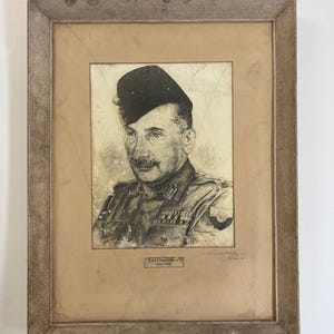 May include: A framed charcoal portrait of a military officer wearing a side cap and uniform with medals. The drawing features a weathered paper texture, a signature in the bottom right, and a small label reading A.M.F.I. Headquarters March 1945.