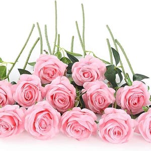 May include: A collection of twelve artificial light pink roses with layered petals, each attached to a long green stem featuring small green leaves. The flowers are arranged in a cluster, showcasing the soft pink color and the detailed petal structure.