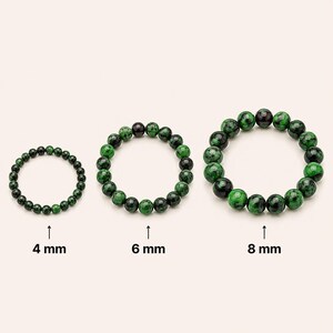 Pode incluir: Três pulseiras circulares feitas de contas de pedra polida com padrões manchados em verde e preto. As pulseiras estão organizadas por tamanho, com etiquetas indicando diâmetros de conta de 4 mm, 6 mm e 8 mm para mostrar a escala.