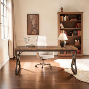 May include: A rectangular wooden desk with a dark brown grain finish and a black metal X-frame base. The desk features a clear glass vase with white flowers, a book, and a table lamp with a white shade and a dark base on its surface.