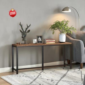 May include: A rectangular console table featuring a dark brown wood-grain surface and a black metal frame. The table has four straight legs and a central support bar. It is decorated with a deer head sculpture, two small frames, and books.