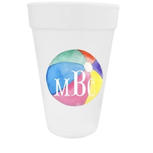 May include: A white plastic cup featuring a circular watercolor graphic of a multi-colored beach ball. The beach ball design includes segments in red, green, blue, and yellow, with the white capital letters MBc centered over the graphic.