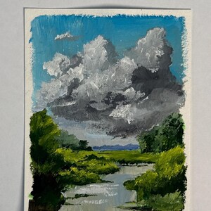 Pode incluir: Uma pintura a óleo sobre papel retratando uma paisagem com um rio sinuoso que flui através de margens verdes e árvores exuberantes. Acima, um céu azul brilhante está cheio de grandes nuvens de tempestade brancas e cinza-escuras.