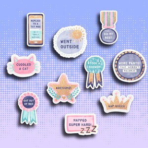 May include: A set of ten colorful stickers with glitter accents and various phrases, including "Went Outside", "Cuddled a Cat", "Got Out of Bed", "Awesome", "Took a Shower", "Wore Pants That Weren't Pajamas", "Replied to a Txt Msg in a Timely Manner", "Did My Best", "Napped Super Hard! ZZZ", and "Nap Queen".