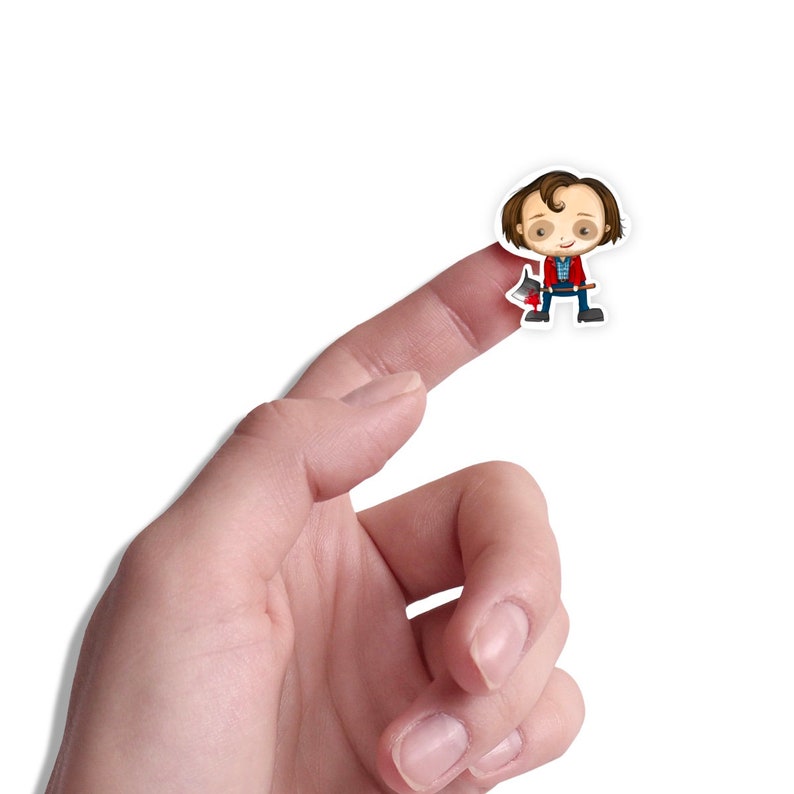 Puede incluir: Una mano sosteniendo una pegatina de un personaje de dibujos animados que lleva una camisa roja y pantalones vaqueros azules, sosteniendo un hacha. El personaje tiene el pelo casta&ntilde;o y una expresi&oacute;n de sorpresa.