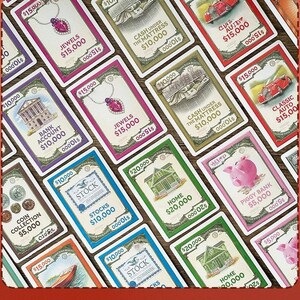 May include: A collection of rectangular game cards featuring illustrations of assets like jewels, cash, cars, houses, and piggy banks. Each card displays a specific dollar value, such as $5,000, $10,000, $15,000, or $20,000, along with text labels like Stocks, Bank Account, and Home.