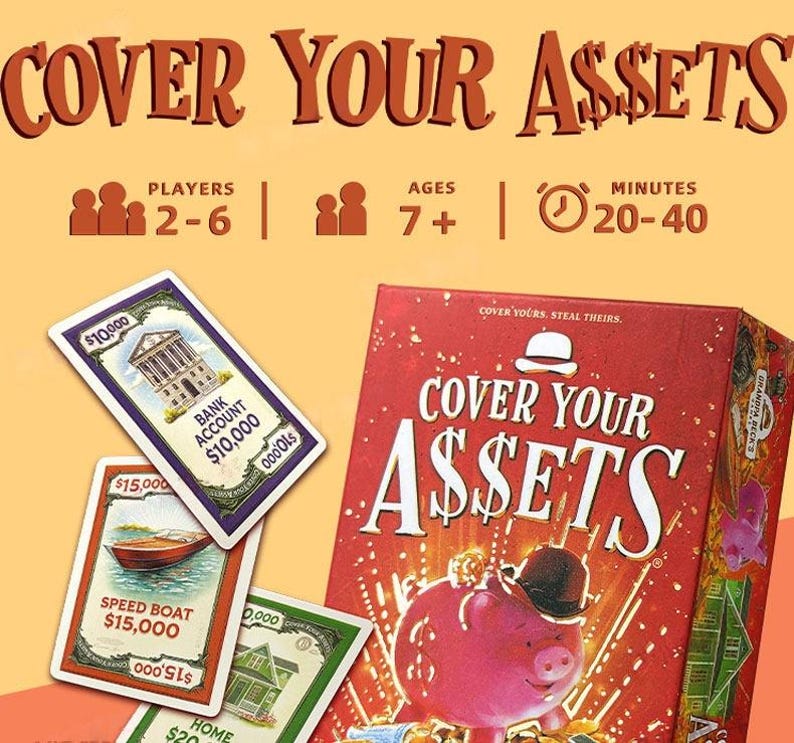 May include: The Cover Your Assets card game box features a red background with a pink piggy bank wearing a black bowler hat. Three game cards are displayed, showing a bank account, a speed boat, and a home. Text includes 2-6 players, ages 7+, and 20-40 minutes.