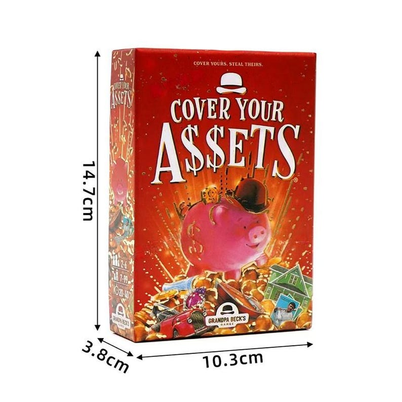 May include: A rectangular card game box titled Cover Your Assets with a red background featuring a pink piggy bank wearing a black hat. The box measures 14.7cm by 10.3cm by 3.8cm and displays illustrations of gold coins, a house, and a red car.
