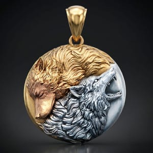 Puede incluir: Un colgante circular con un diseño en relieve de dos lobos. Un lobo está representado en oro pulido con los ojos cerrados, mientras que el otro está en plata con la boca abierta aullando. El colgante incluye una reasa de oro en la parte superior.