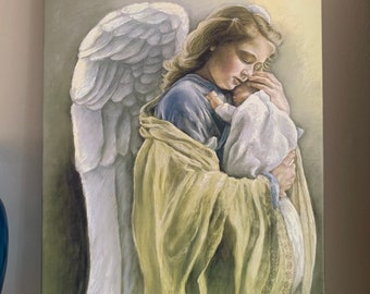 Op de afbeelding: Een schilderij van een engel met grote witte vleugels die een baby in haar armen houdt. De engel draagt een gele robe met gouden versieringen en een blauwe onderjurk. De baby is gewikkeld in een witte deken.