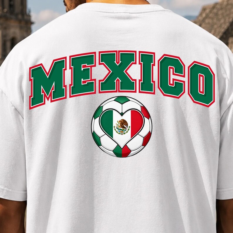 Op de afbeelding: Een wit t-shirt met het woord MEXICO in grote groene letters met een rode omlijning in een boogvorm. Onder de tekst staat een voetbalafbeelding met een hartvormig midden in de kleuren van de Mexicaanse vlag: groen, wit en rood.