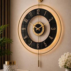 May include: A circular wall clock featuring a black ring with gold numerals from 1 to 12, a central gold dial with a 60-second track, gold hands, and a gold pendulum. The clock is framed by a thin gold ring with integrated warm LED lighting.