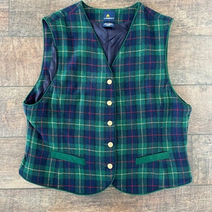 May include: A green, blue, red, and yellow plaid vest with gold buttons and a green velvet trim. The vest has a label that reads "Liz Claiborne".