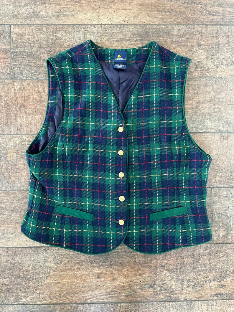 May include: A green, blue, red, and yellow plaid vest with gold buttons and a green velvet trim. The vest has a label that reads "Liz Claiborne".