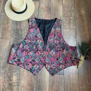 May include: A multi-colored vest with a patchwork design featuring pink, green, gold, and black. The vest has a V-neck and a button closure.