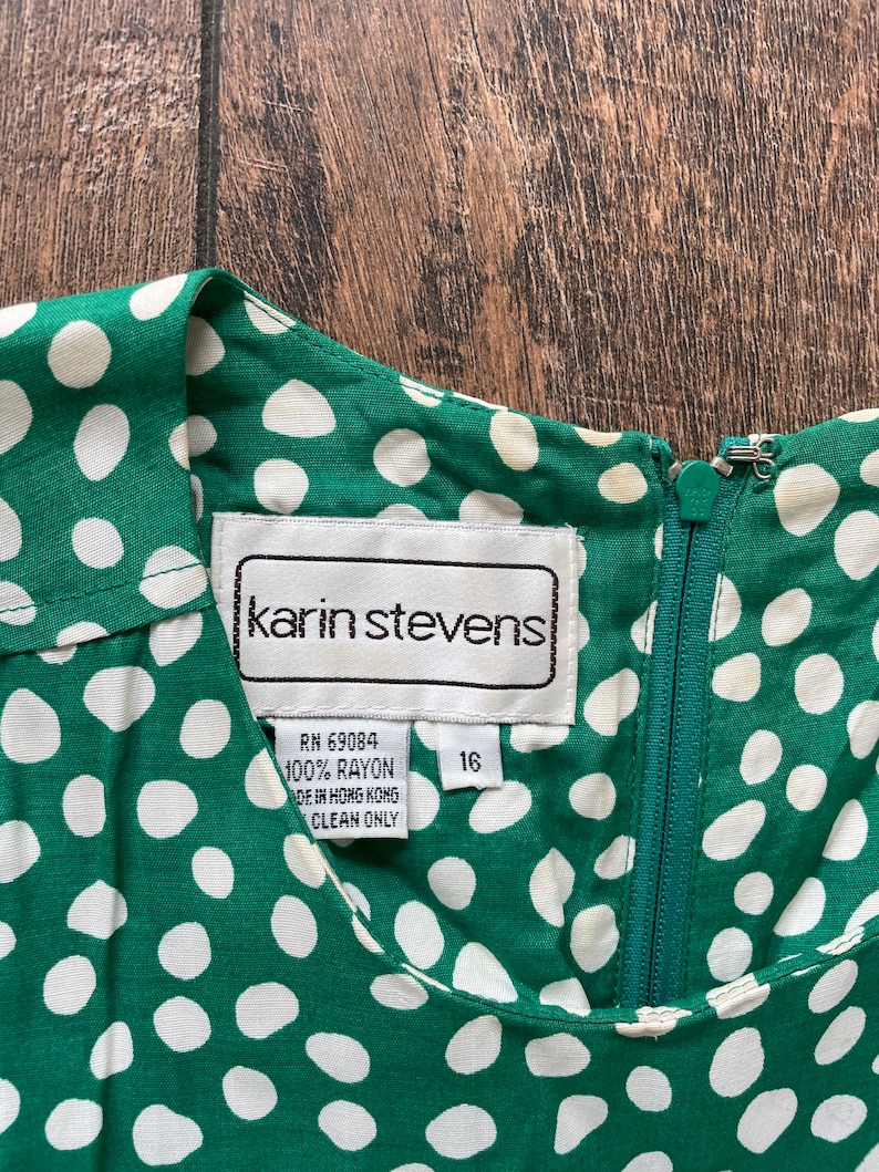 May include: A green and white polka dot rayon dress with a zipper closure and a label that reads "karin stevens" and "RN 69084 100% RAYON MADE IN HONG KONG CLEAN ONLY" and "16".