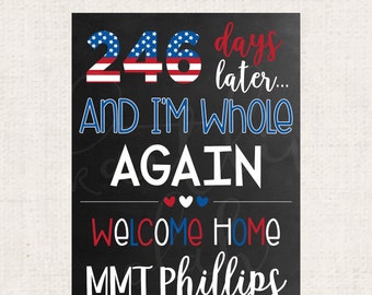 May include: Black chalkboard sign with white text that reads "246 days later... and I'm whole again. Welcome home MMT Phillips". The number 246 is decorated with red, white, and blue stars and stripes. There are three small red, white, and blue hearts below the text "whole again".
