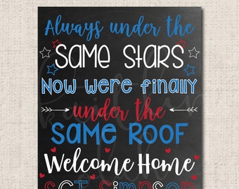 May include: Black rectangular sign with white, red, and blue text. The sign reads "Always under the SAME STARS, Now were finally under the SAME ROOF, Welcome Home, SGT SIMPSON."