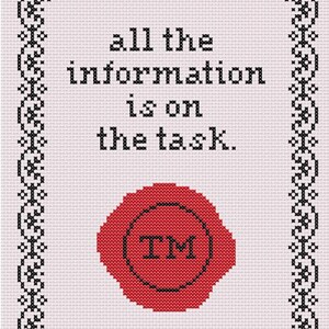May include: A cross-stitch pattern on light pink fabric featuring a black decorative border and the text "all the information is on the task." Below the text is a red circular wax seal design with the black letters "TM" centered inside the circle.