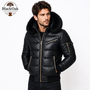 Könnte beinhalten: Eine schwarze Leder-Daunenjacke mit einer großen, pelzbesetzten Kapuze, einem durchgehenden Frontreißverschluss und mehreren Reißverschlusstaschen an Brust und Ärmeln. Das Logo von Black Oak Leather Goods ist oben links im Bild zu sehen.