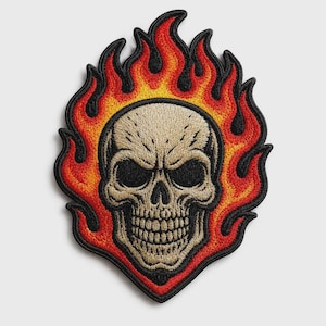 May include: An embroidered patch featuring a beige human skull centred within a vibrant flame design. The flames transition from yellow at the base to orange and red at the tips, all outlined with a thick black border and detailed stitching.