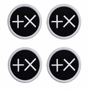 May include: Four circular embroidered patches featuring a black background with a white border. Each patch displays a white plus sign and a white multiplication sign symbol centered on the black fabric, creating a consistent graphic design.