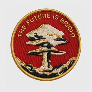May include: A circular embroidered patch featuring a red background with a gold border. In the center, a white and black mushroom cloud design is depicted. The text THE FUTURE IS BRIGHT is embroidered in gold lettering along the top edge.