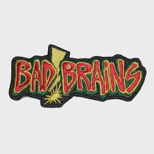 Könnte beinhalten: Ein gestickter Aufnäher mit dem Schriftzug BAD BRAINS in roten Buchstaben mit gelber Umrandung. Ein gelbes Blitzsymbol ist in den Buchstaben A integriert. Das gesamte Design ist mit einem dicken, schwarzen Stickrand auf schwarzem Grund versehen.