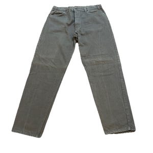 May include: A pair of solid gray denim jeans featuring a standard five-pocket design, a button fly closure, and a straight-leg cut. The fabric has a consistent matte finish with visible stitching along the seams, waistband, and pockets.