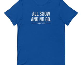May include: A royal blue short-sleeve t-shirt featuring the white distressed-style text ALL SHOW AND NO GO. centered on the chest, with the text TORQUE & TIN positioned below the main phrase between two horizontal lines.