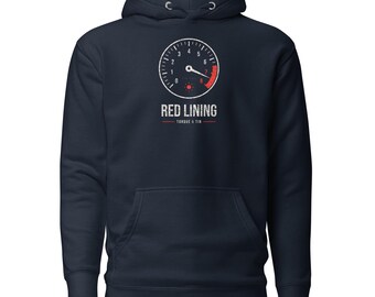 May include: A navy blue hooded sweatshirt featuring a graphic of a tachometer gauge with a red zone. Below the gauge, the text reads RED LINING and TORQUE & TIN in a distressed white font. The hoodie includes a front kangaroo pocket.