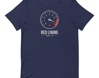 May include: A navy blue short-sleeve t-shirt featuring a white and red tachometer graphic on the chest. Below the gauge, the text reads RED LINING and TORQUE & TIN in a distressed white font, with red horizontal lines flanking the bottom text.