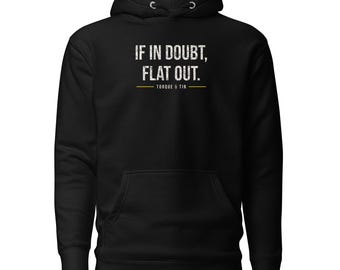 May include: A black hooded sweatshirt featuring the white distressed text IF IN DOUBT, FLAT OUT. centered on the chest, with the text TORQUE & TIN positioned below the main phrase, separated by a thin horizontal gold line.