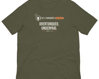 May include: An olive green short-sleeve t-shirt featuring a graphic of a torque wrench above the white text that reads OVERTORQUED. UNDERPAID. and the smaller text TORQUE & TIN with two horizontal lines on either side.