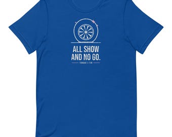 May include: A royal blue short-sleeve t-shirt featuring a white graphic of a car wheel centred on the chest. Below the wheel, the text reads ALL SHOW AND NO GO. with the words TORQUE & TIN printed underneath, flanked by two horizontal lines.