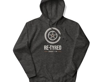 May include: A dark charcoal heather gray hooded sweatshirt featuring a white graphic of a car tire and wheel. Below the graphic, the text reads RE-TYRED in a distressed white font, followed by the words TORQUE & TIN in smaller letters.
