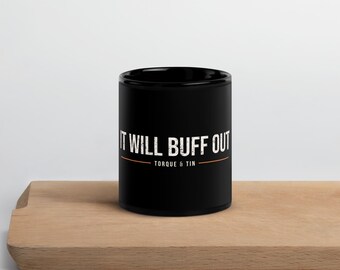 May include: A black ceramic mug featuring the white distressed text IT WILL BUFF OUT printed on the front, with the words TORQUE & TIN positioned below the text, separated by a thin horizontal orange line.