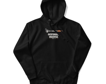 May include: A black hooded sweatshirt featuring a graphic of a silver and orange torque wrench above the white text "OVERTORQUED. UNDERPAID." and smaller text "TORQUE & FIX" centered on the chest, with a front kangaroo pocket and drawstrings.