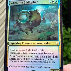 May include: A foil Magic: The Gathering trading card titled Whtz, the Bibliophile. The artwork depicts a small, round creature with a large eye in a glass helmet carrying a sack of books. The card text includes abilities, power and toughness 1/3.