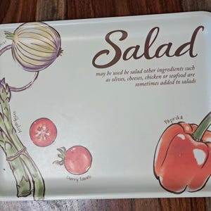 May include: A rectangular off-white serving tray featuring illustrations of an onion, asparagus, cherry tomatoes, and a red bell pepper. The text reads Salad may be used be salad other ingredients such as olives, cheeses, chicken or seafood.