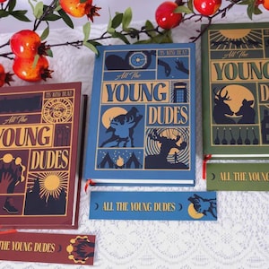 May include: Three hardcover books titled All the Young Dudes by Ms King Bean, featuring graphic covers in maroon, blue, and green. Each book includes a matching rectangular bookmark with the same title and thematic illustrations of animals.