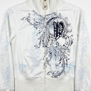 May include: A white zip-up track jacket featuring a high collar and long sleeves. The front displays a dark blue graphic print of a large letter P surrounded by ornate scrollwork and cherub figures, with light blue floral patterns on the sleeves.