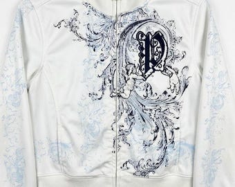 May include: A white zip-up track jacket featuring a high collar and long sleeves. The front displays a dark blue graphic print of a large letter P surrounded by ornate scrollwork and cherub figures, with light blue floral patterns on the sleeves.
