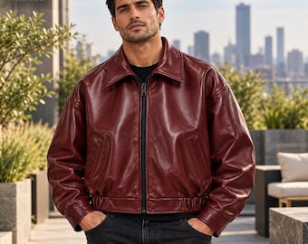 May include: A deep burgundy leather jacket with a classic collar, a full-length front zipper, and an elasticized hem. The jacket features long sleeves with cuffs and two side pockets. The ORIXO LEATHER logo is visible in the top left corner.