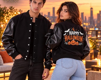 May include: Two black varsity jackets with leather sleeves and snap buttons. The jacket on the right features a graphic on the back with orange pumpkins, white bats, and the text Happy Halloween in orange and white lettering.
